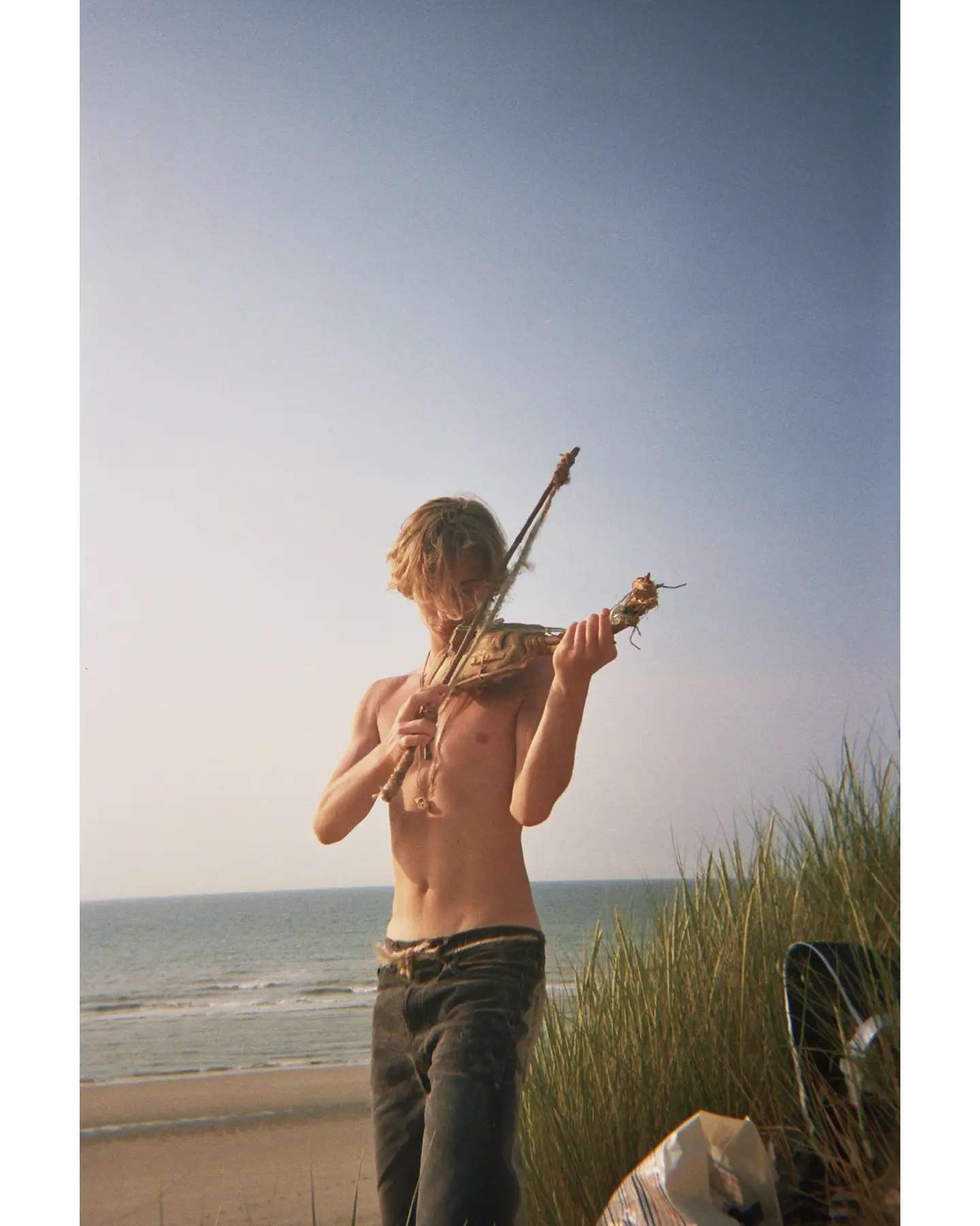 Abel jouant du violon face à la mer.