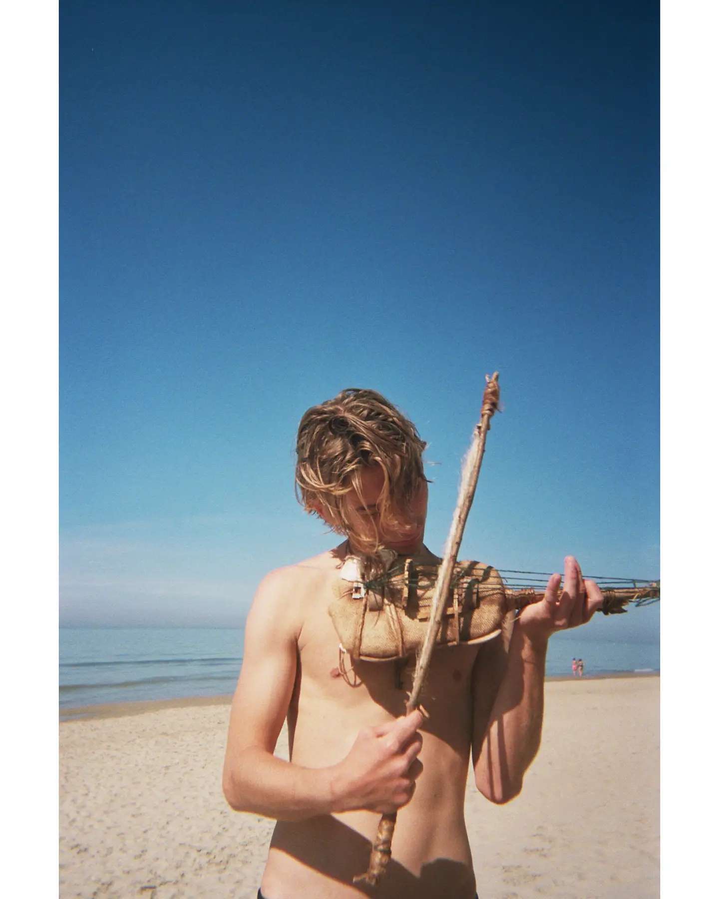 Portrait d’Abel au violon sur la plage.